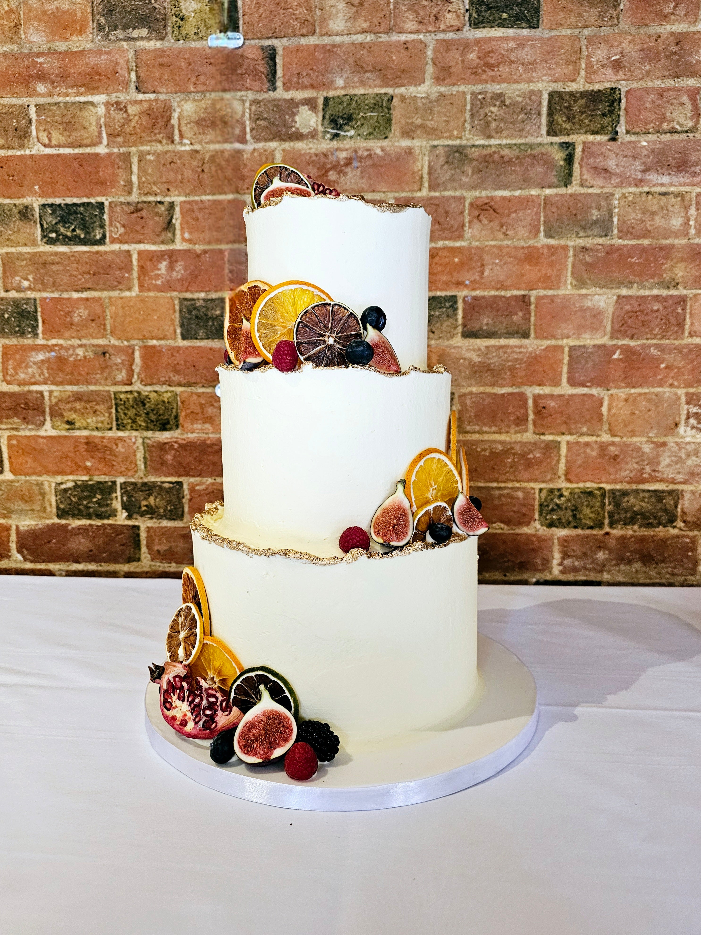 Rustic Buttercream Wedding Cake with Seasonal Fruits and Gold Accents - Cake Secret