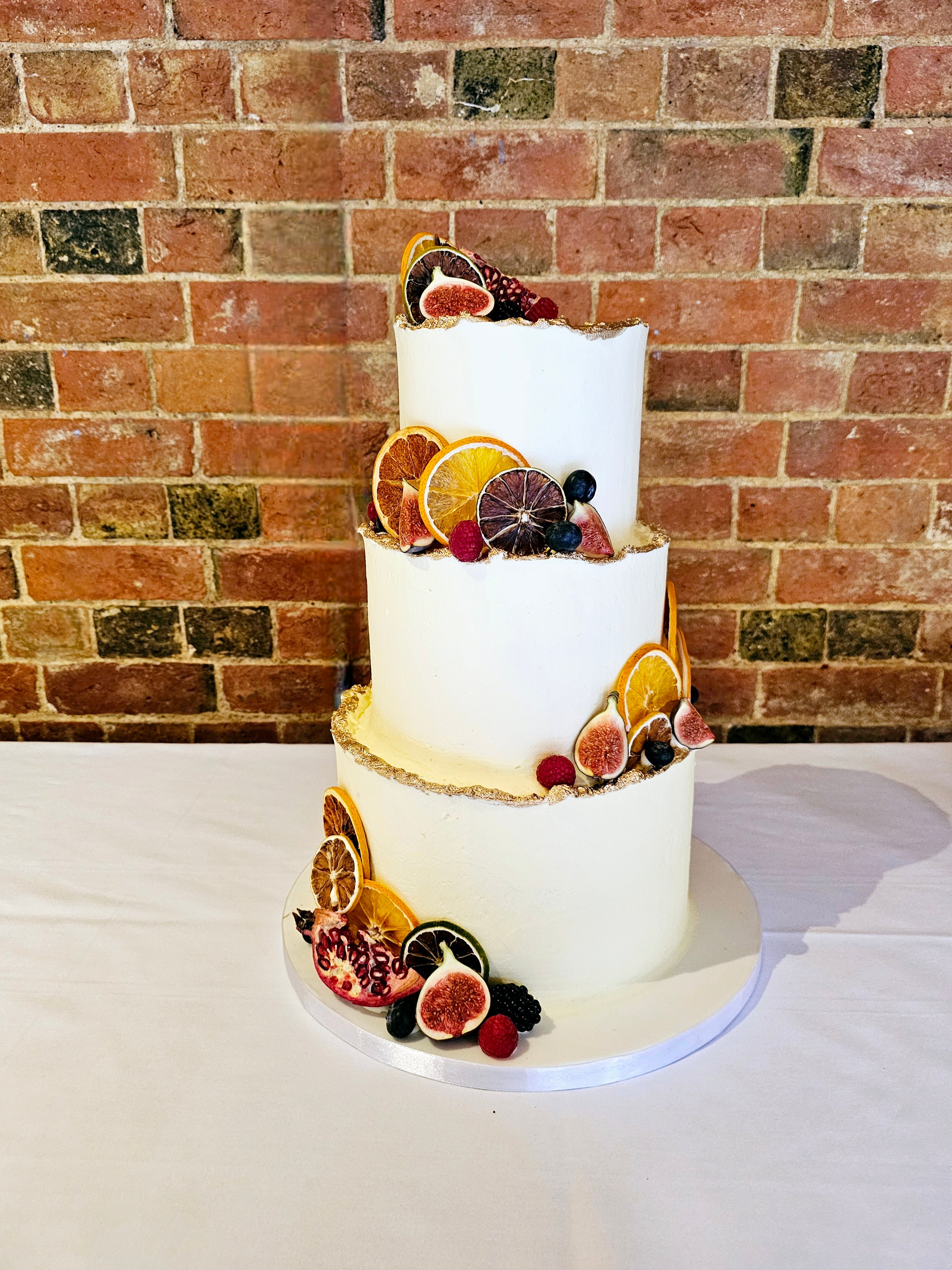 Rustic Buttercream Wedding Cake with Seasonal Fruits and Gold Accents - Cake Secret