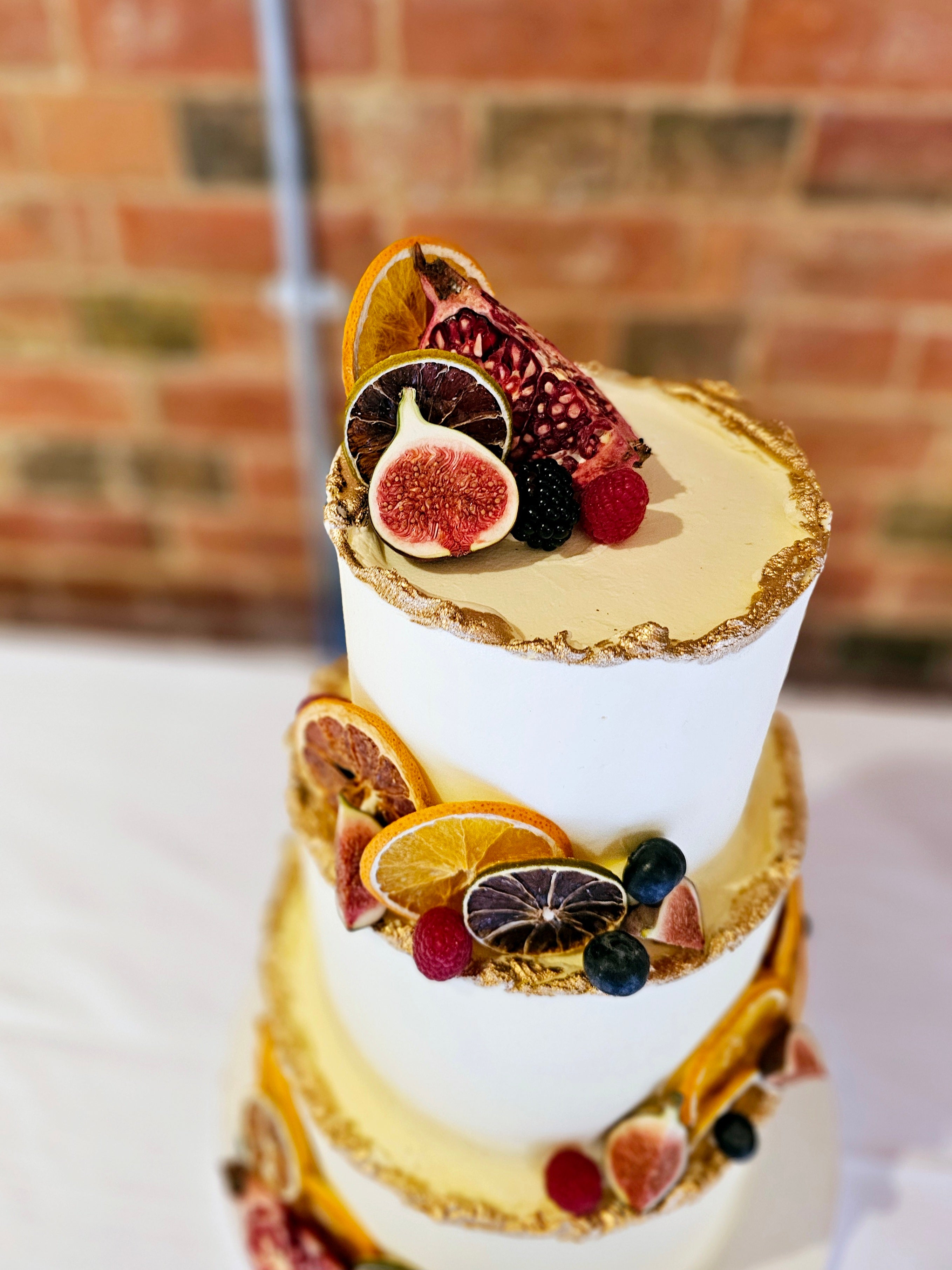 Rustic Buttercream Wedding Cake with Seasonal Fruits and Gold Accents - Cake Secret